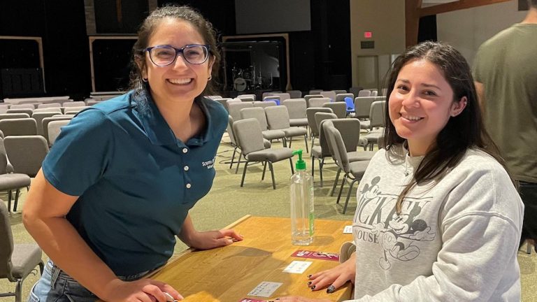 Caroline Silva (left) and Natalia Aguilar assist with registration.